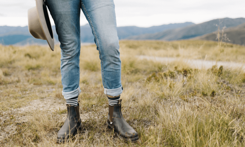 Person wearing boots and jeans in nature, showcasing an adventurous vibe as their ultimate travel companion.