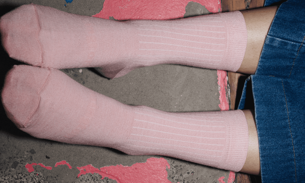 person weaing knee high pink lamington merino wool socks