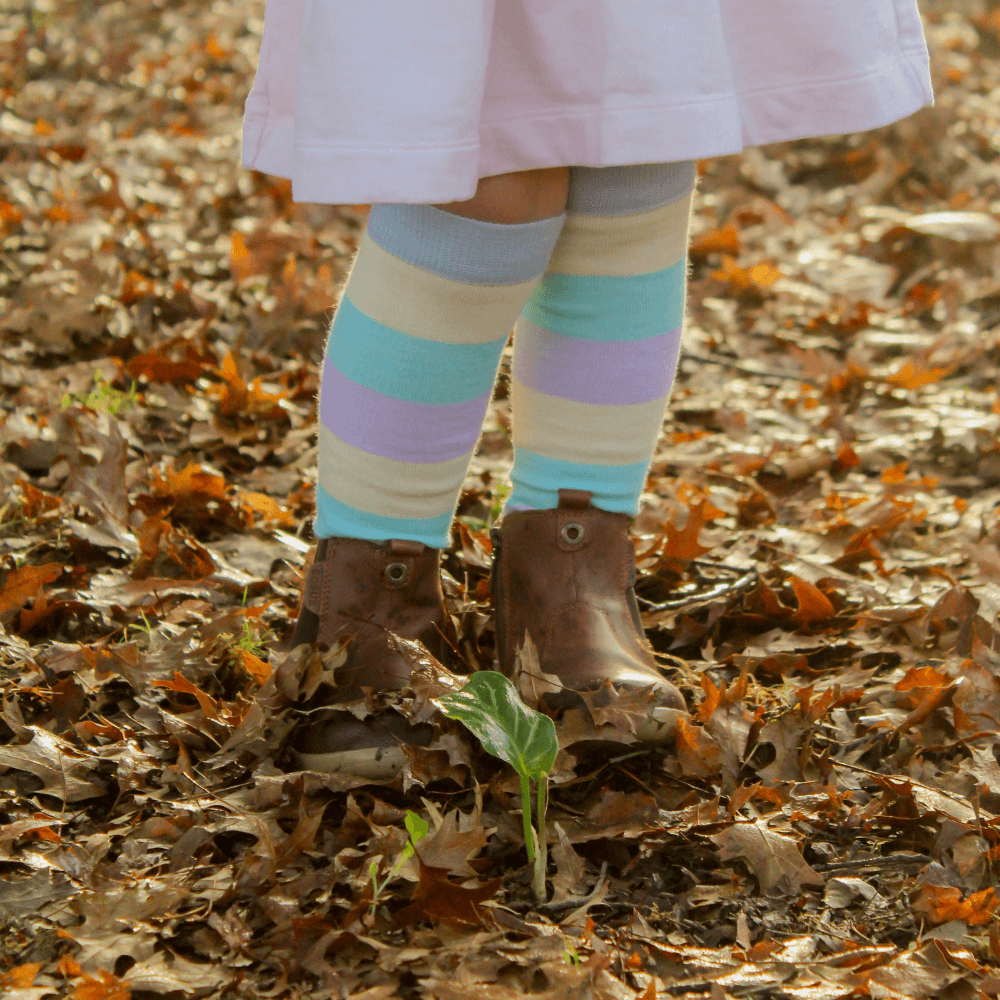 Merino Wool Knee High Socks for Child in pastel stripes of blue, yellow, green, and purple, providing warmth and comfort.