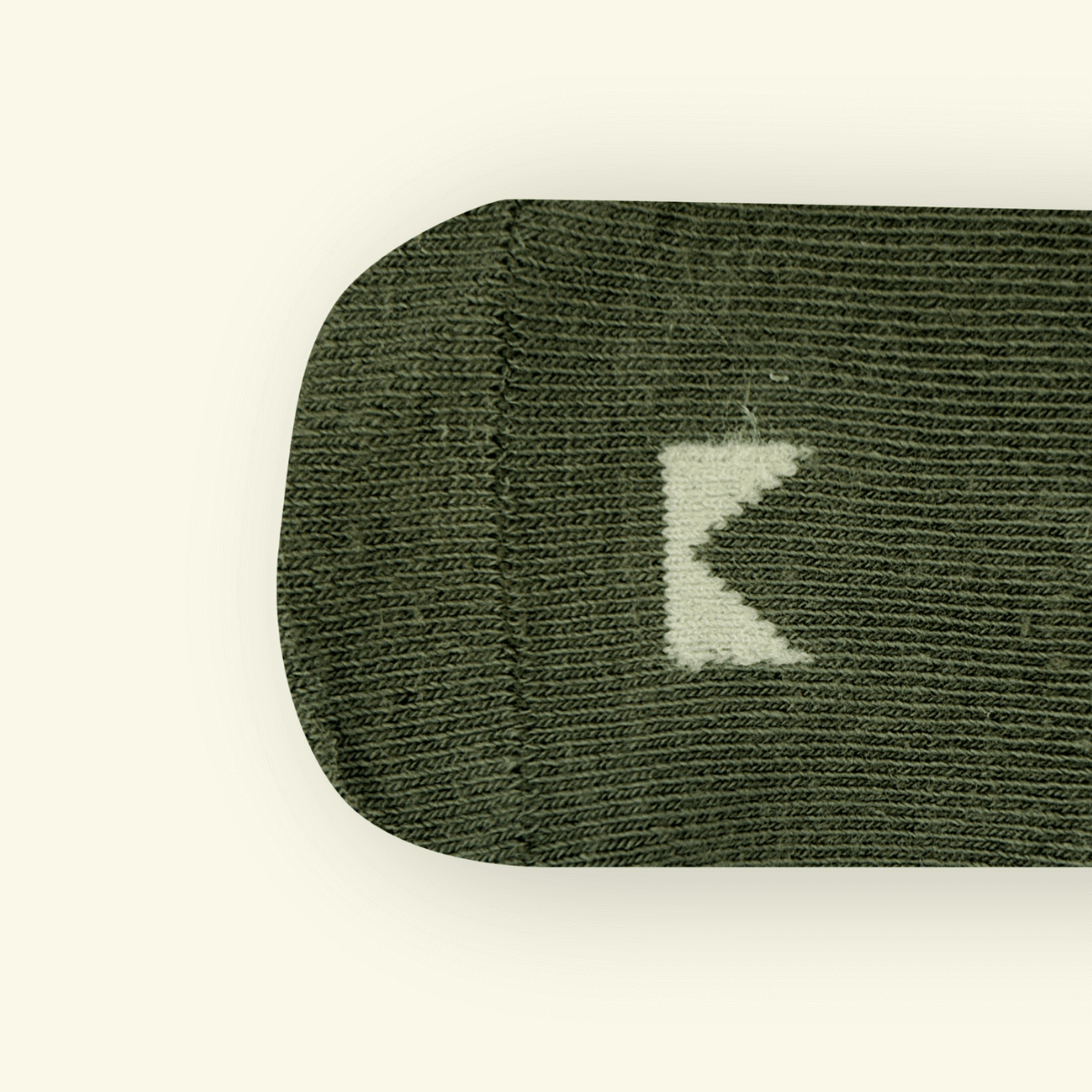 Close-up of Organic Cotton Baby Socks in Sage color showing the Mosey logo on the toe area.